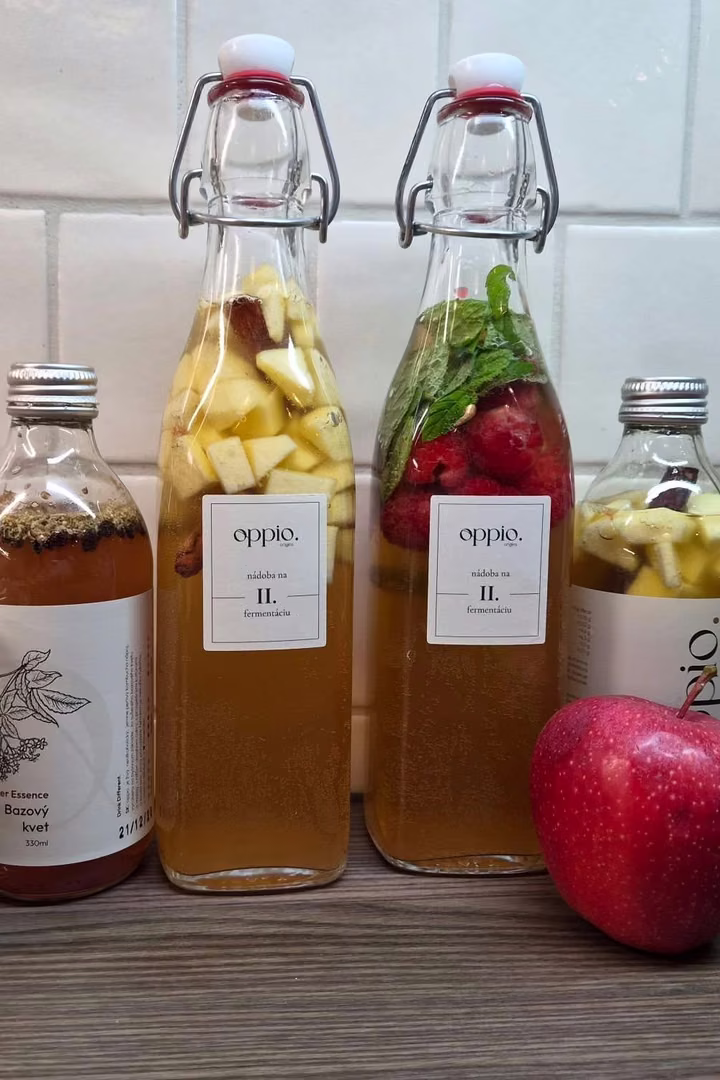 Domácí kombucha z kitu oppio. při druhé fermentaci – láhev s jablkem a skořicí a láhev s malinami a mátou